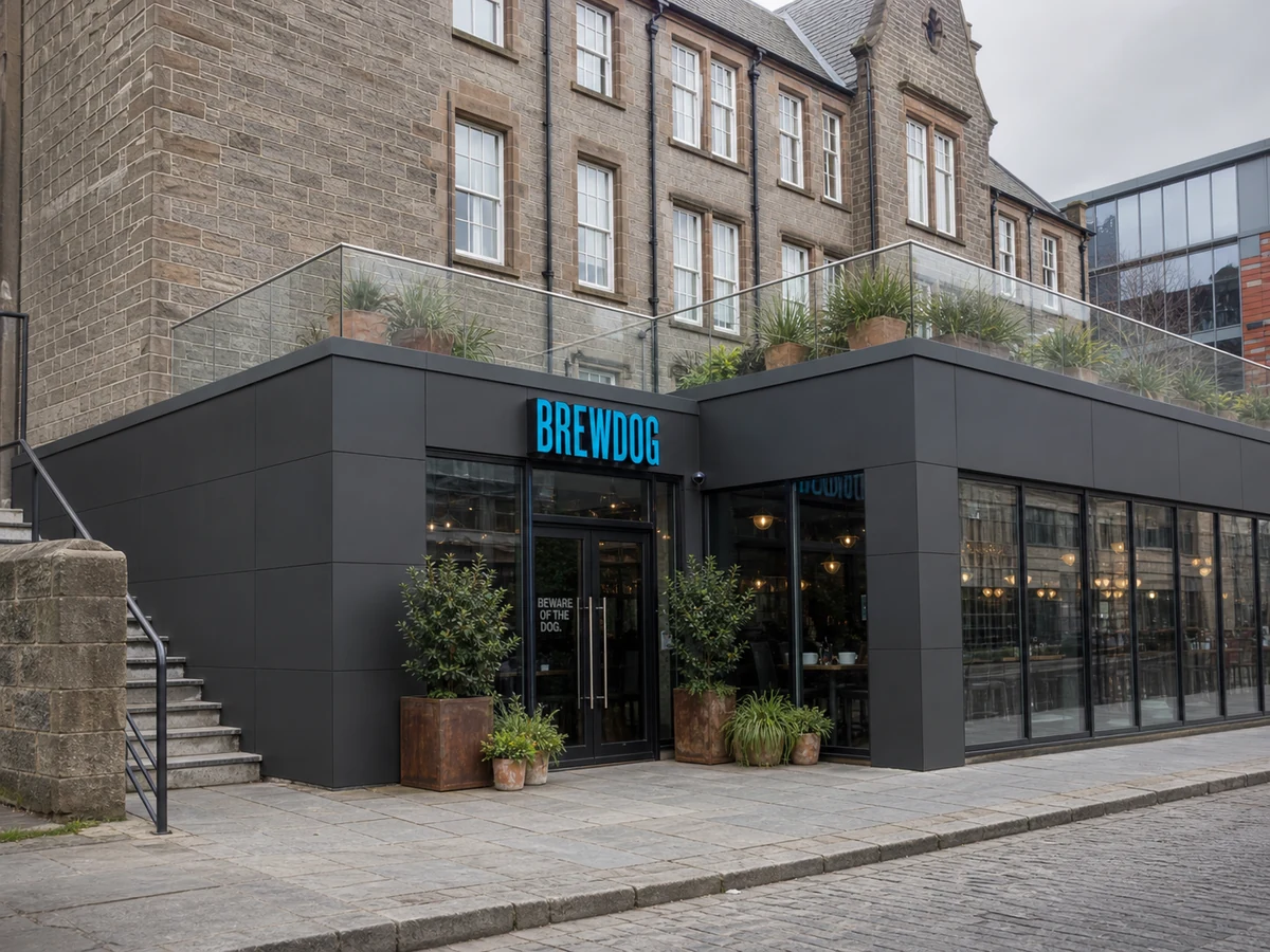 BrewDog DogHouse Edinburgh’s black glass frontage on New Street, set below the historic stone building and terrace.