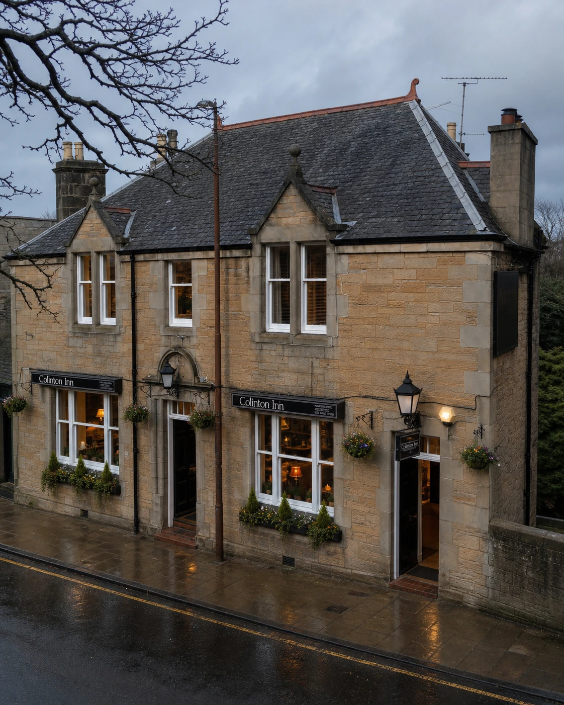 Colinton Inn’s buff sandstone frontage with twin gables, slate roof, broad windows and two entrances.