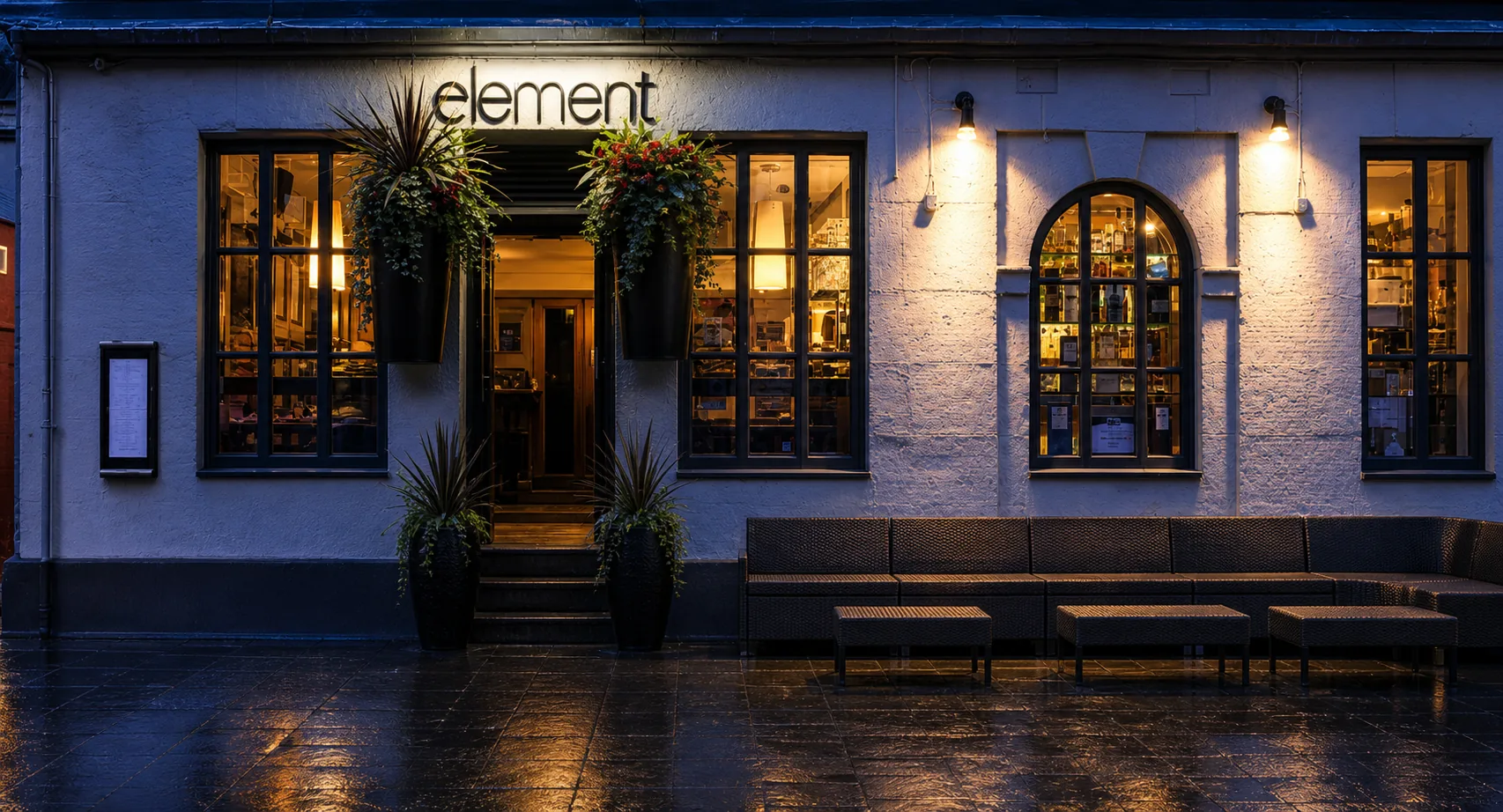 Element’s named Rose Street frontage, with arched window, hanging planters and warm glow.