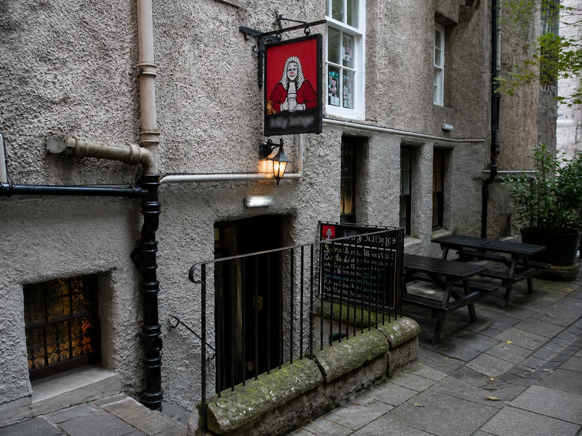 The Jolly Judge’s hidden James Court basement entrance with its red judge sign, black railings and warm lantern.