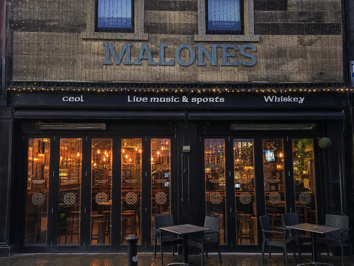 Malones’ real-source-led Morrison Street frontage, with named weathered timber, string lights and warm live-music windows.