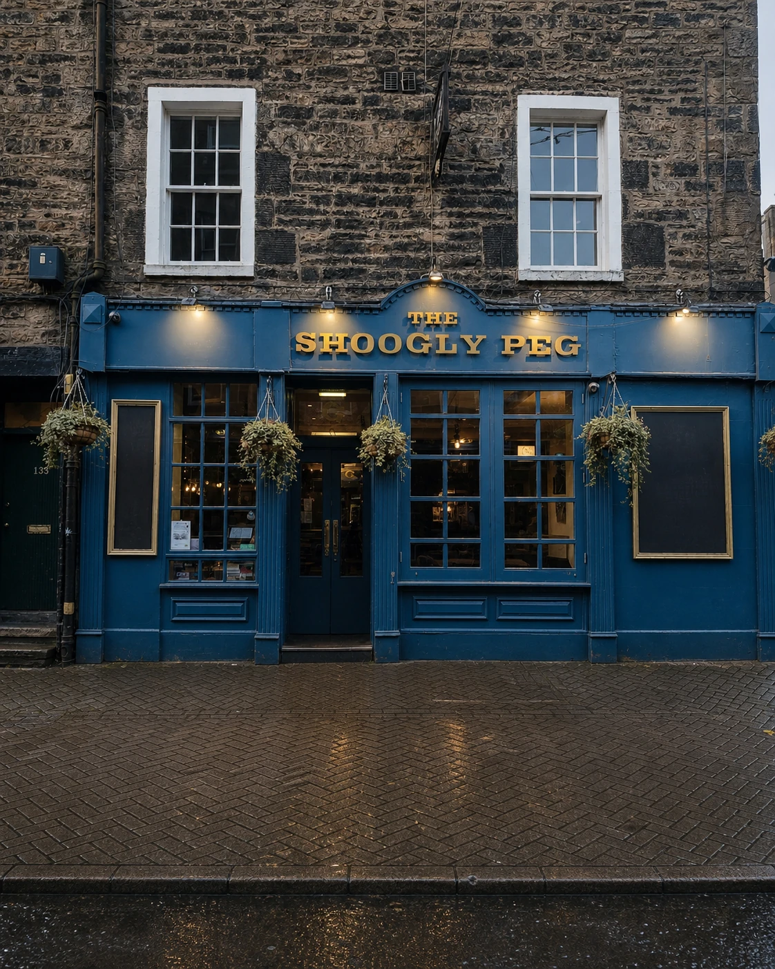 The Shoogly Peg’s exact blue Rose Street frontage, with raised gold name, paired sash windows and rain-darkened paving.