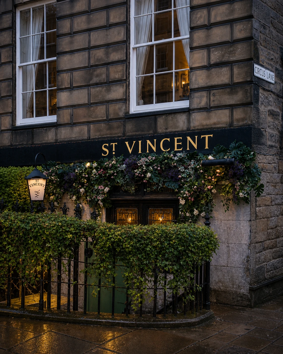 St Vincent Bar’s flower-covered basement entrance below the dark stone terrace at Circus Lane.