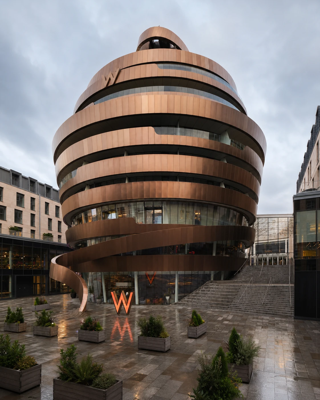 W Lounge’s exact W Edinburgh Ribbon Building, its bronze spiral bands, glowing W entrance and rain-wet St James Square.