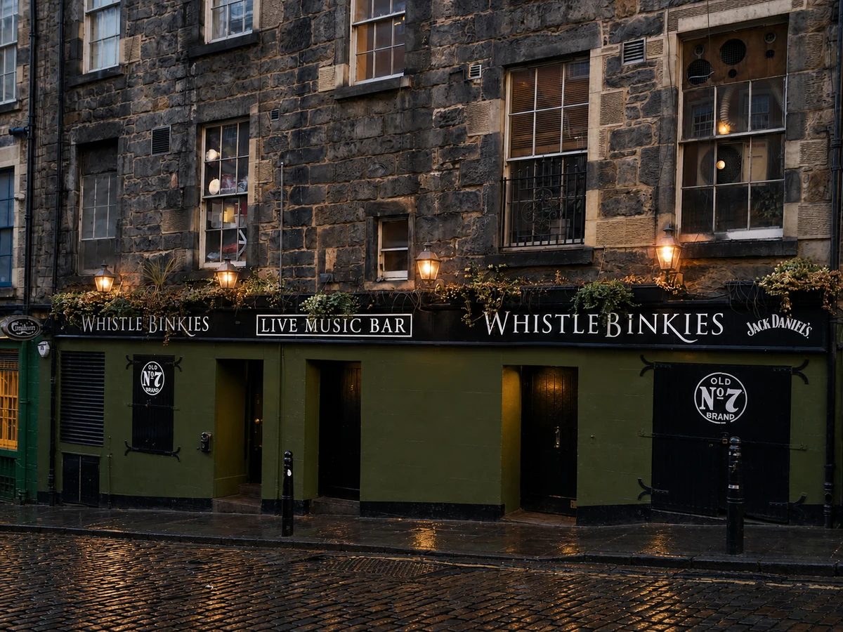 Whistle Binkies’ source-led sandstone and olive-green South Bridge frontage, with crisp “WHISTLE BINKIES” and “LIVE MUSIC BAR” signs.