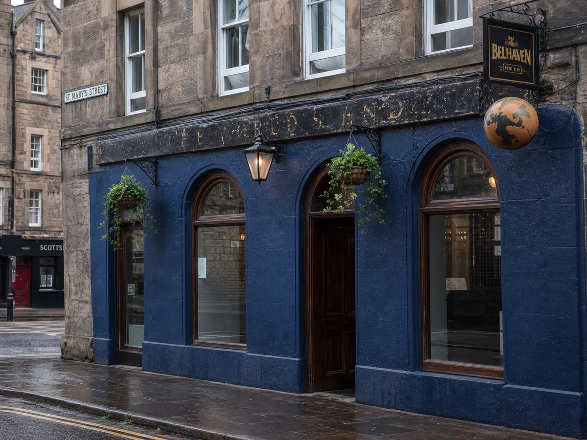 The World’s End’s cobalt-blue High Street frontage with arched openings, lantern, hanging baskets and Belhaven sign.